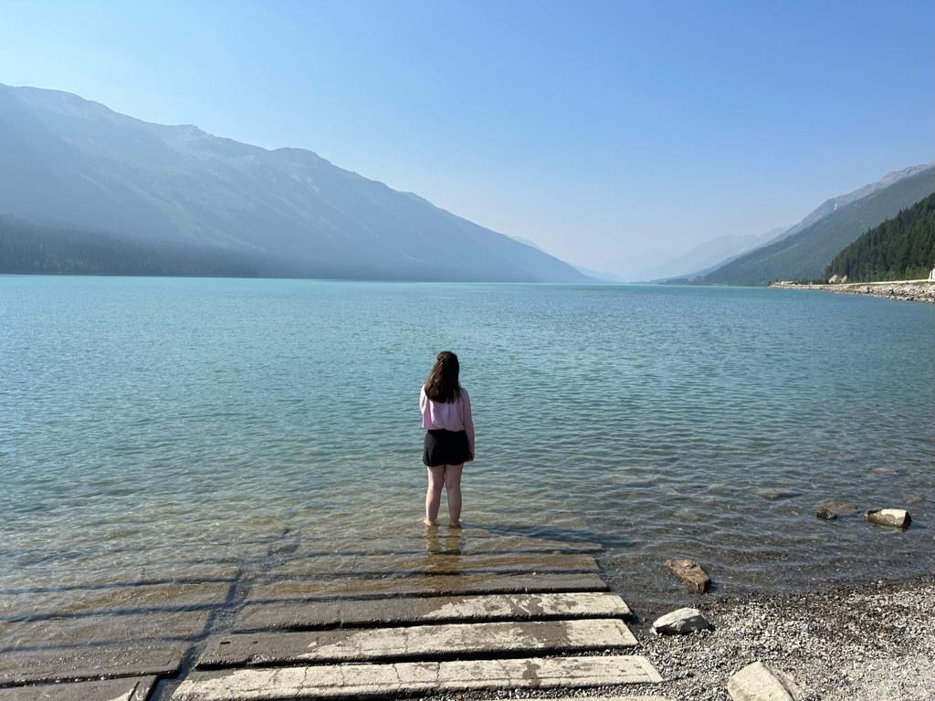 Standing quietly by the calm mountain lake waters